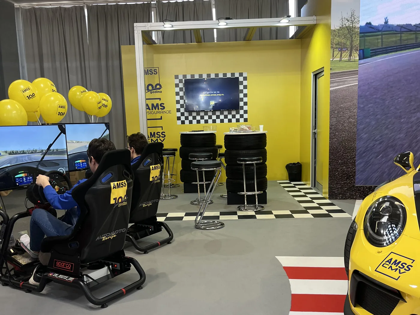 Sim Master stand at a car show, AMSS “100 godina” and a yellow Porsche